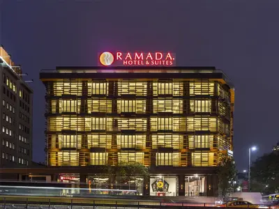 a building with a sign on top of it at night at Ramada Hotel & Suites Sisli in Istanbul