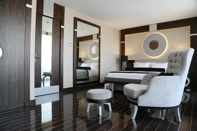 a bedroom with a bed and a chair and a mirror at Ramada Hotel & Suites Sisli in Istanbul