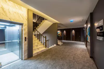 a hallway with a staircase in a building at Ezkar Bathonea Art İstanbul Hotel in Avcılar