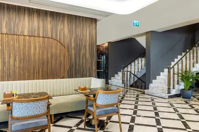 a lobby with a couch and a table and chairs at Ezkar Bathonea Art İstanbul Hotel in Avcılar