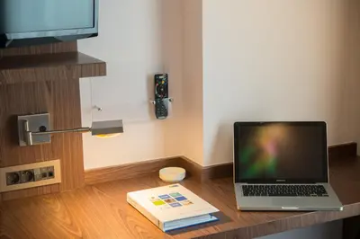 a laptop computer sitting on a desk with a book at Liv City Hotels in Istanbul
