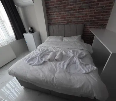 a white bed with two pairs of shoes on it at lastbest hotel in Istanbul