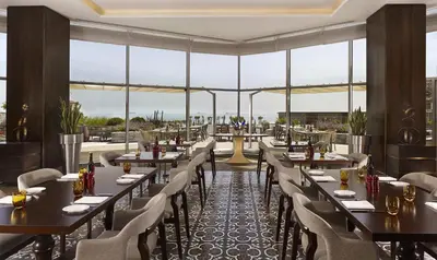 a restaurant with tables and chairs and large windows at Hyatt Regency Istanbul Atakoy in Istanbul