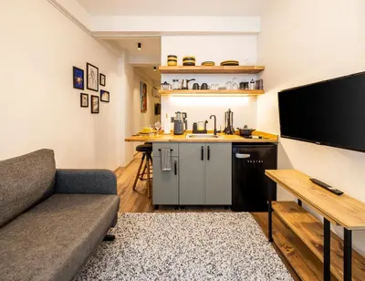 a living room with a couch and a kitchen at Mariposa Rooms Taksim in Istanbul