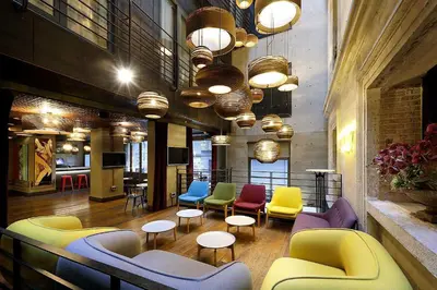 a lobby with colorful chairs and tables and lights at Hotel The Public - Special Category in Istanbul