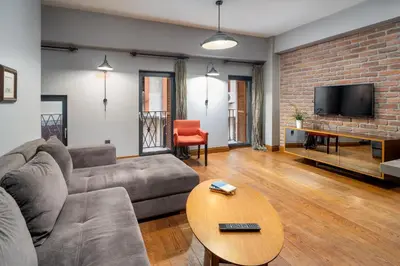 a living room with a couch and a brick wall at Urban Quarters - Asmalı Mescit in Istanbul