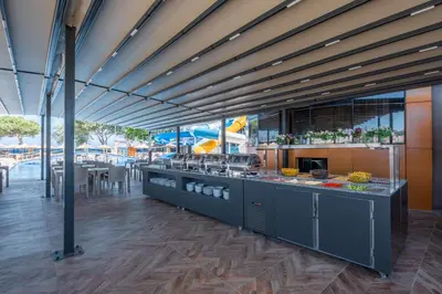 a large kitchen with a counter with a table at Avsa Artemis Hotel in Avsa Adasi