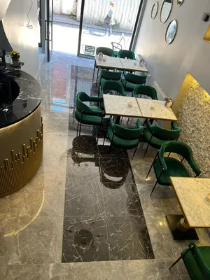 a row of tables and green chairs in a room at dolphin hotel cafe in Istanbul