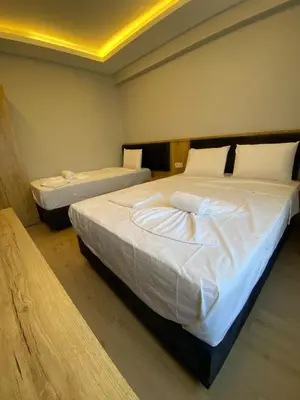 a bedroom with two beds with white sheets at dolphin hotel cafe in Istanbul