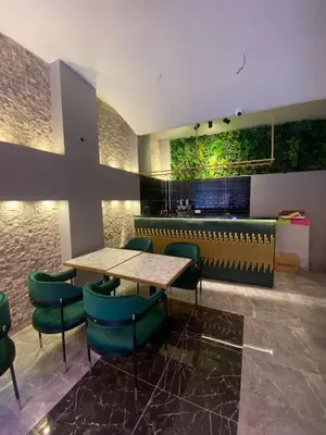 a restaurant with a table and some green chairs at dolphin hotel cafe in Istanbul