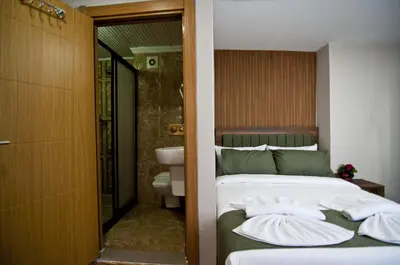 a bedroom with a bed and a bathroom with a toilet at Aurora Eco Hotel in Istanbul