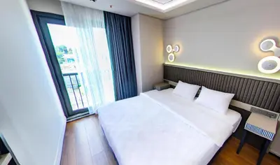 a bedroom with a white bed and a large window at Theodosius Hotel in Istanbul