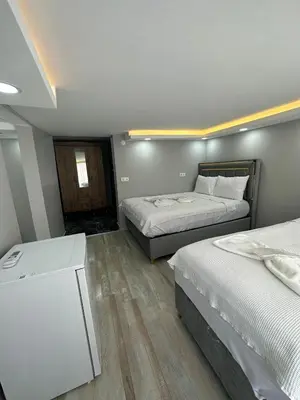 a bedroom with two beds and a table in it at IMMOR AKKUS HOTEL in Istanbul
