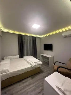 a bedroom with a bed and a tv and a couch at ASLAN AİRPORT Hotel in Arnavutköy