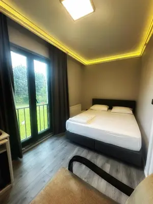 a bedroom with a bed and large windows at ASLAN AİRPORT Hotel in Arnavutköy