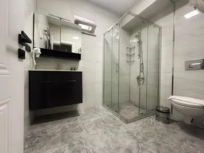 a bathroom with a glass shower and a toilet at ASLAN AİRPORT Hotel in Arnavutköy