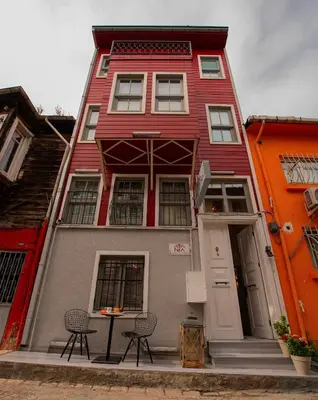 a red building with two chairs in front of it at NİA SULTANAHMET in Istanbul