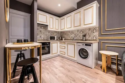 a kitchen with white cabinets and a washer and dryer at Sedef Apartments Pera in Istanbul