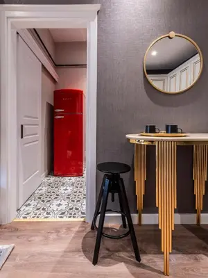 a red refrigerator in a room with a table and a stool at Sedef Apartments Pera in Istanbul