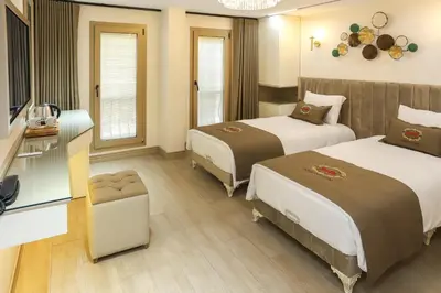 a hotel room with two beds and a television at Safa Hotel Old City in Istanbul