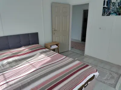 a bedroom with a bed with a striped blanket at Villaferhat mavi in Karacaköy
