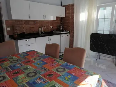 a kitchen with a table with chairs and a table cloth at Villaferhat mavi in Karacaköy