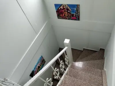 a staircase with two pictures on the wall at Villaferhat mavi in Karacaköy