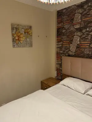 a bedroom with a bed and a stone wall at Sea view House in Istanbul