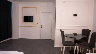 a room with a table and a tv on a wall at Global Termal Hotel in Çekirge