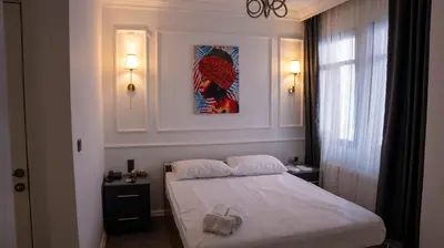 a bedroom with a bed and a painting on the wall at Global Termal Hotel in Çekirge