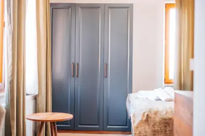 a bedroom with blue cabinets and a bed and a table at Mysia Olympos Hotel in Bursa
