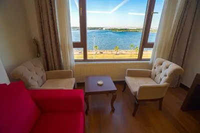 a living room with a couch and a large window at Sea Garden Otel in Darıca