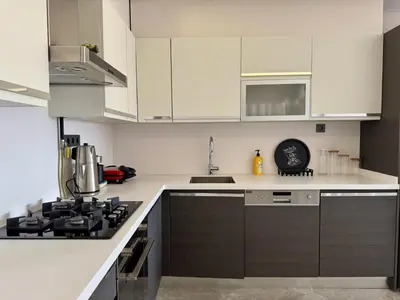 a kitchen with white cabinets and a stove top oven at Bomonti 42 Suites in Istanbul