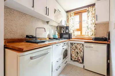 a kitchen with white cabinets and a wooden counter top at Villa Arancia Istanbul - Garden, BBQ, Sauna & Turkish Bath by the Tram in Fatih in Istanbul