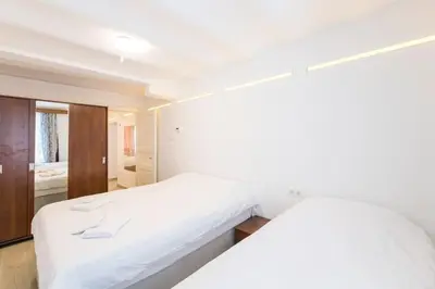 a white bedroom with a bed and a bathroom at Beautiful 2BR House w/AC 400meters Taksim Square in Istanbul