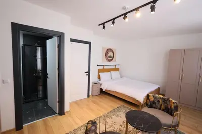 a white bedroom with a bed and a chair at Evra Suites Hotel in Istanbul