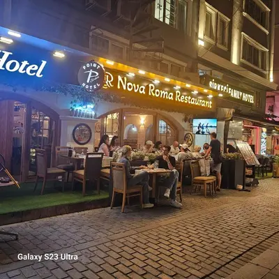 people sitting at tables in a restaurant at night at Hatay Hotel in Istanbul