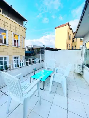 a patio with white chairs and a table on a roof at Taksim Ottoman Style Hotel in Istanbul
