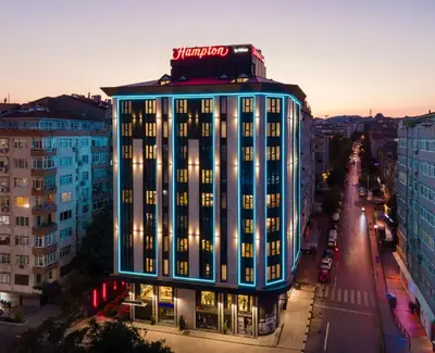 a building with a neon sign on top of it at Hampton By Hilton Istanbul Merter in Istanbul