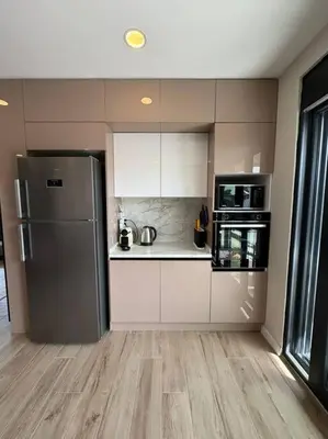 a kitchen with a stainless steel refrigerator and white cabinets at Luxurious 3BR Izmit Apartments- Mountain View in Çavuşçiftliği