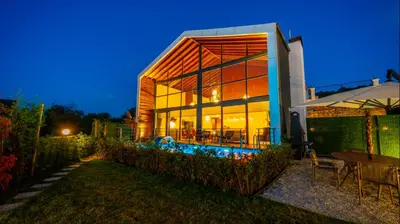 a home with a large glass building at night at Trio Palazio Sapanca in Sapanca