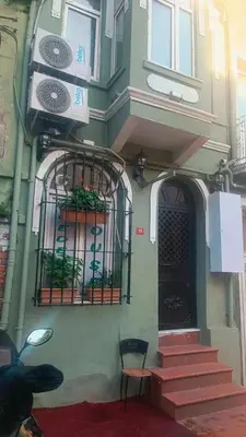 a green building with two gates and a stair case at Taksim academie house in Istanbul