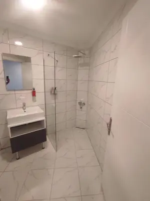 a white bathroom with a sink and a shower at Cevvo Hotel Pendik in Istanbul