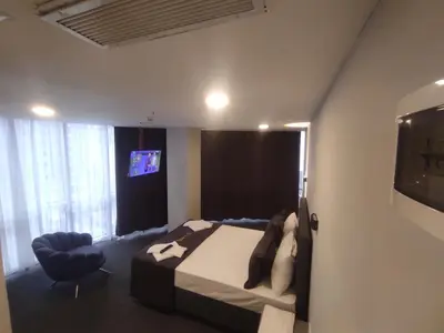 a bedroom with a bed and a chair and a tv at Cevvo Hotel Pendik in Istanbul