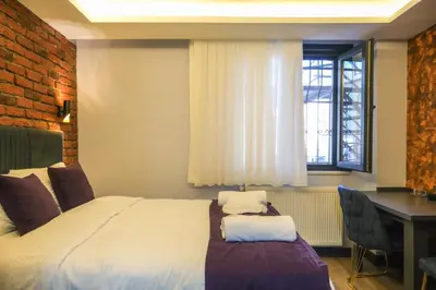 a bedroom with a bed and a desk and a window at mansion yellow hotel in Istanbul