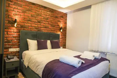 a bedroom with a bed with a brick wall at mansion yellow hotel in Istanbul