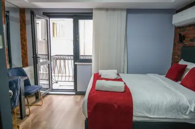 a bedroom with a large bed and a balcony at mansion yellow hotel in Istanbul