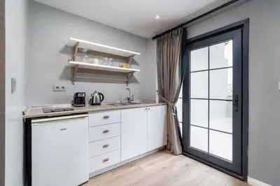 a kitchen with white cabinets and a large window at Urban Quarters - Tepebaşı in Istanbul