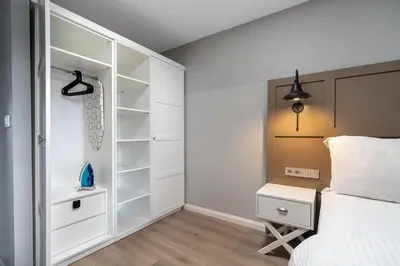 a bedroom with a bed and a night stand next to a closet at Urban Quarters - Tepebaşı in Istanbul