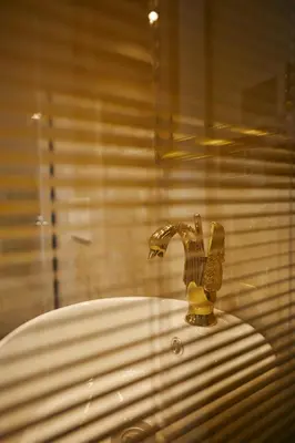 a bathroom sink with a gold faucet in a window at Mitspark in Istanbul